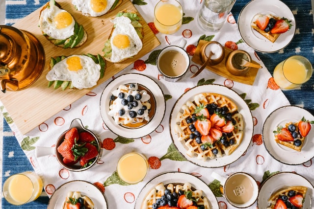 Waffles, juices, toast along with other breakfast items on the table -daily routine of a student in English 